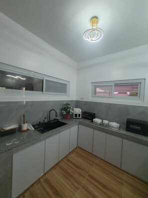 A modern kitchen with a built-in oven, a sink, and a window above the countertop.