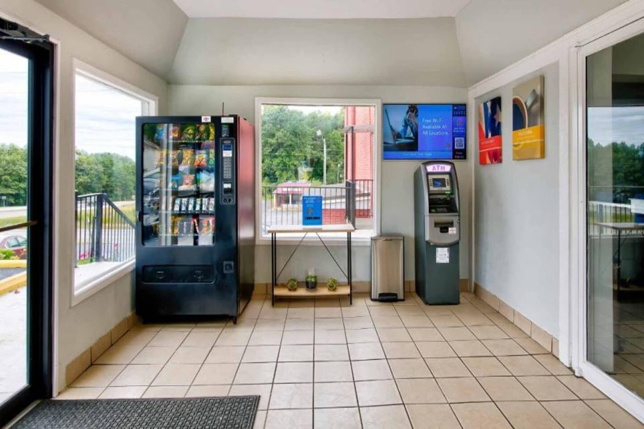Une pièce équipée d’un distributeur automatique, d’un guichet automatique et d’une fenêtre donnant sur l’extérieur.