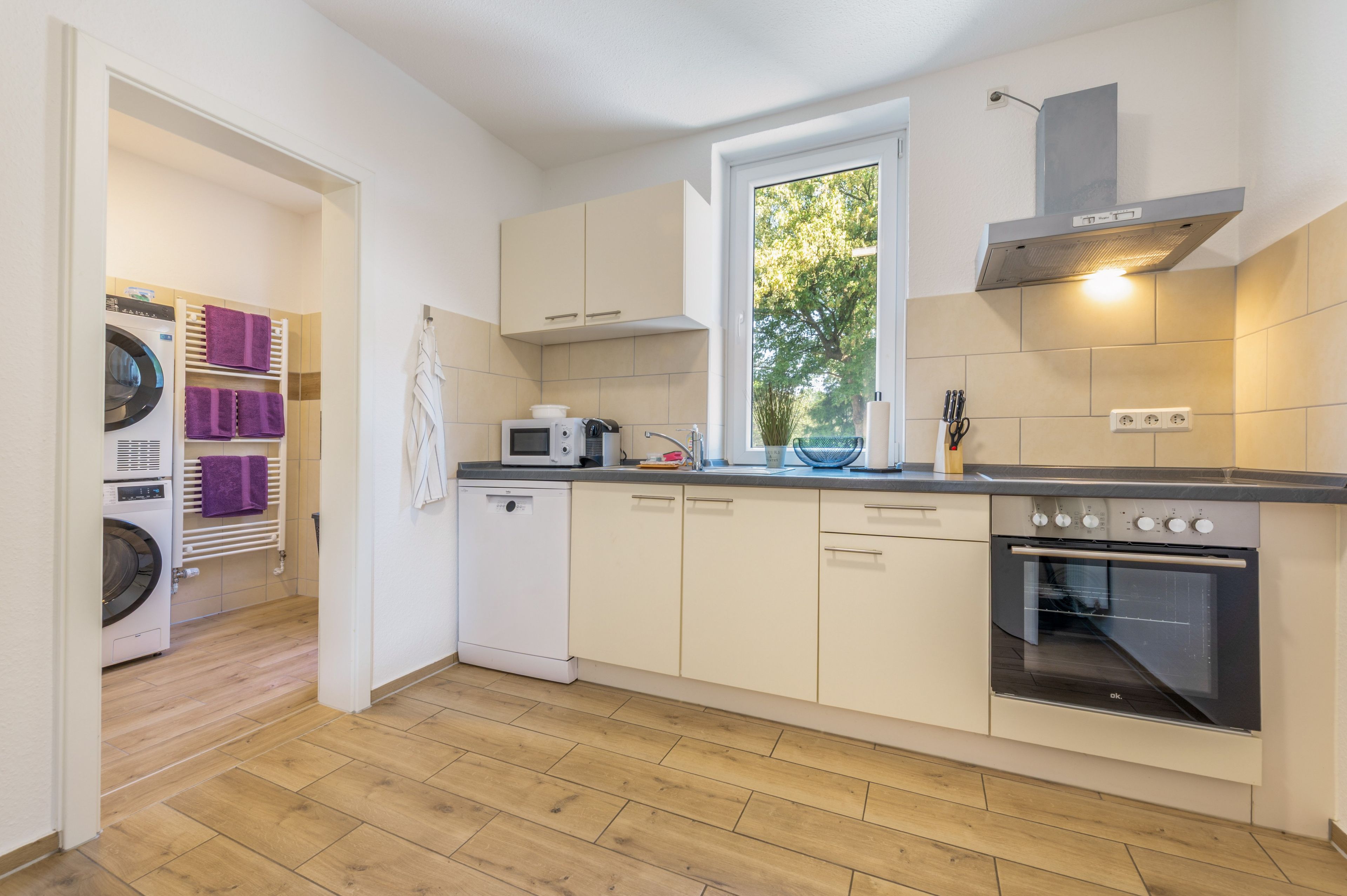 Eine moderne Küche mit Backofen, Mikrowelle und einem Fenster für natürliches Licht.