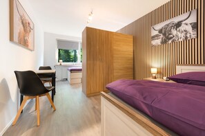 Ein modernes Schlafzimmer mit einem Bett, einem Schreibtisch und einem Stuhl.