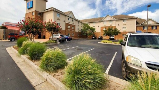 A hotel with a parking lot, multiple buildings, and a clear sky. - 2 Full Beds|Non-Smoking,Kitchen (Richmond VA)