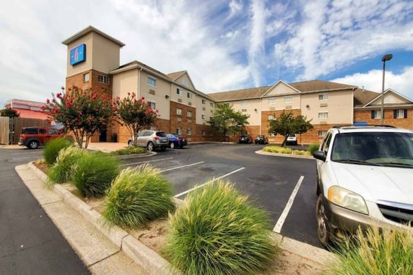 A hotel with a parking lot, multiple buildings, and a clear sky. - 2 Full Beds|Non-Smoking,Kitchen (Richmond VA)