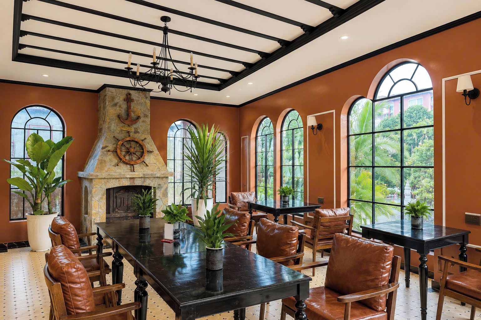Une salle à manger spacieuse avec une cheminée en pierre, des fauteuils en cuir et de grandes fenêtres donnant sur un paysage verdoyant.