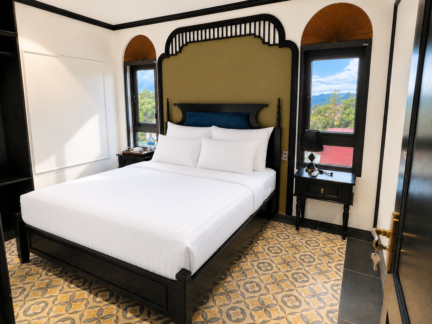 Habitación de hotel con una cama grande, una mesita de noche, un ventanal con vistas y un suelo estampado.