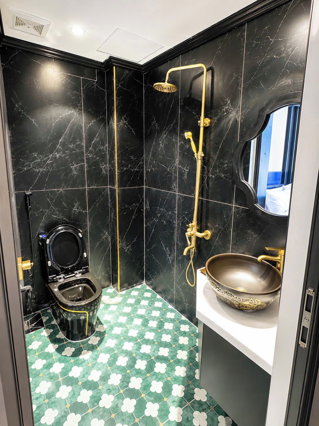 A bathroom with a toilet, a shower, and a sink.
