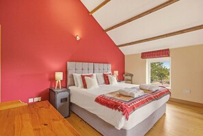 A bedroom with a bed, bedside table, lamp, and a window with a view. - Drum Barn Roses Bower - North East Escapes (Great Whittington)