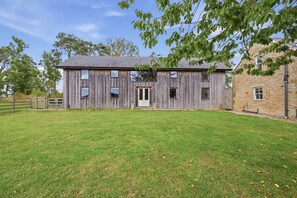 A rustic barn-style building with a wooden exterior, a front door, and a small porch. - Drum Barn Roses Bower - North East Escapes (Great Whittington)
