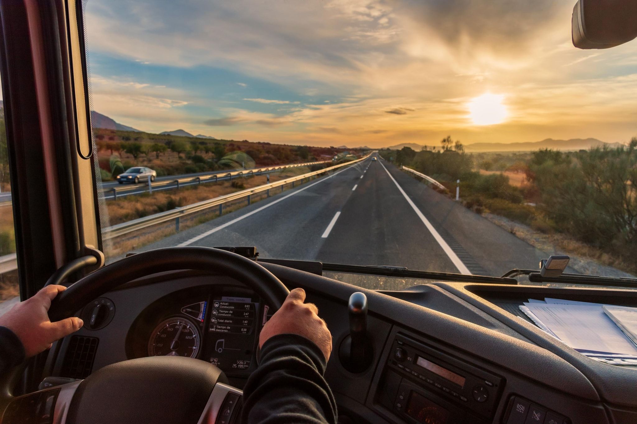 Tablero de un vehículo con volante, velocímetro y palanca de cambios.