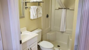 Een badkamer met toilet, wastafel en douche.
