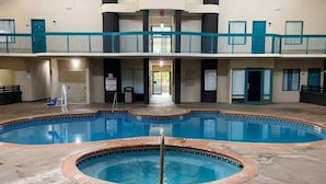 An indoor swimming pool with a hot tub in the center, surrounded by a pool deck. - Spacious Queen Bed Room|Free Wifi (Savannah GA)