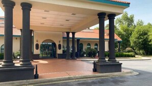 A building with a covered entrance, columns, and a tiled roof. - Spacious Queen Bed Room|Free Wifi (Savannah GA)