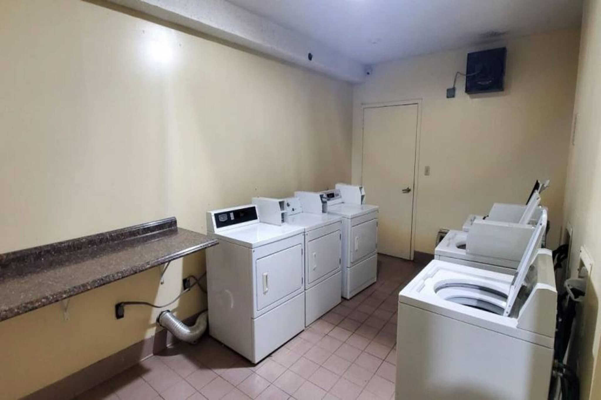 Un cuarto de lavandería con lavadora, secadora y secadoras apiladas.