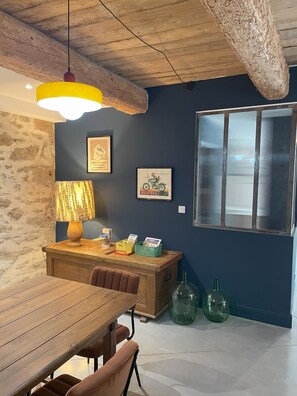 A dining area with a wooden table, chairs, a lamp, and a wall with framed pictures. - The Domaine de la Feuilleraie   (Montséret)