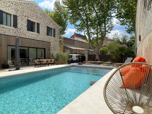 A swimming pool with a stone building and outdoor seating area. - The Domaine de la Feuilleraie (Montséret)
