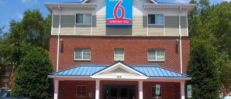 A two-story building with a sign for 'Studio 6 Extended Stay.'