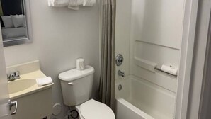 Et badeværelse med toilet, håndvask og bruser.