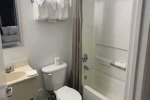 Une salle de bain avec des toilettes, un lavabo et une douche.