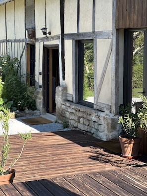 A rustic building with a stone foundation, wooden beams, and a wooden deck.