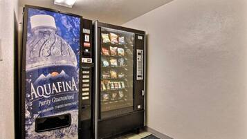Una macchina che eroga acqua con una grande pubblicità di Aquafina e una macchina distributrice di snack affiancata.