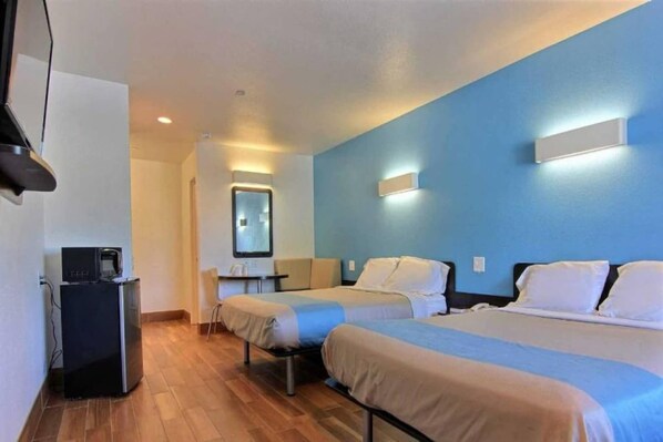 A hotel room with two beds, a desk, a chair, a television, and a mirror. - 2 Queen Beds | Non-Smoking (Rockport)