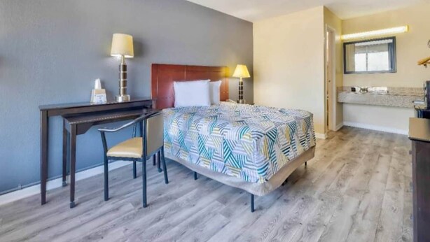 A hotel room with a bed, desk, chair, and a small kitchenette area. - 1 Queen Bed | Non-Smoking, Micfridge (Effingham)
