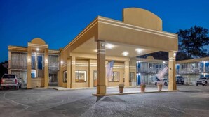 A hotel with a covered entrance, multiple balconies, and a parking lot. - 1 Queen Bed | Non-Smoking, Micfridge (Effingham)