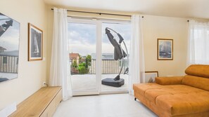 Un dormitori modern amb una finestra gran, un sofà i obres d'art a les parets.