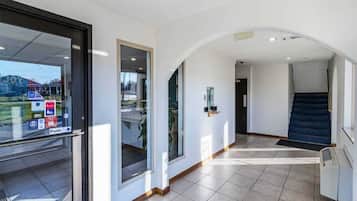 A modern interior with a tiled floor, a staircase, and a glass door with a 'Push' sign.