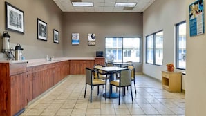 A hotel lobby with a reception desk, wooden cabinets, a tiled floor, and large windows. - 1 King Bed | Non-Smoking, Kitchen (Effingham)