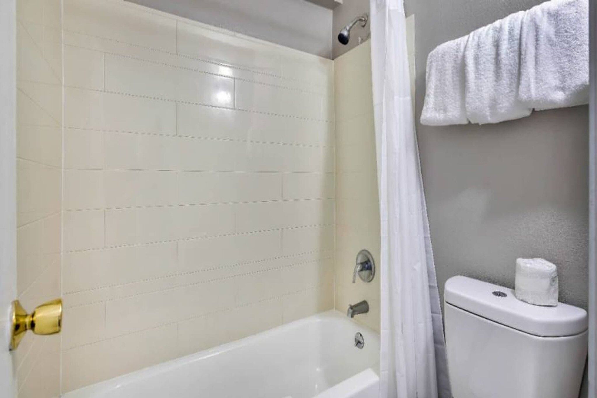 Une salle de bain avec une baignoire, des toilettes et un rideau de douche.