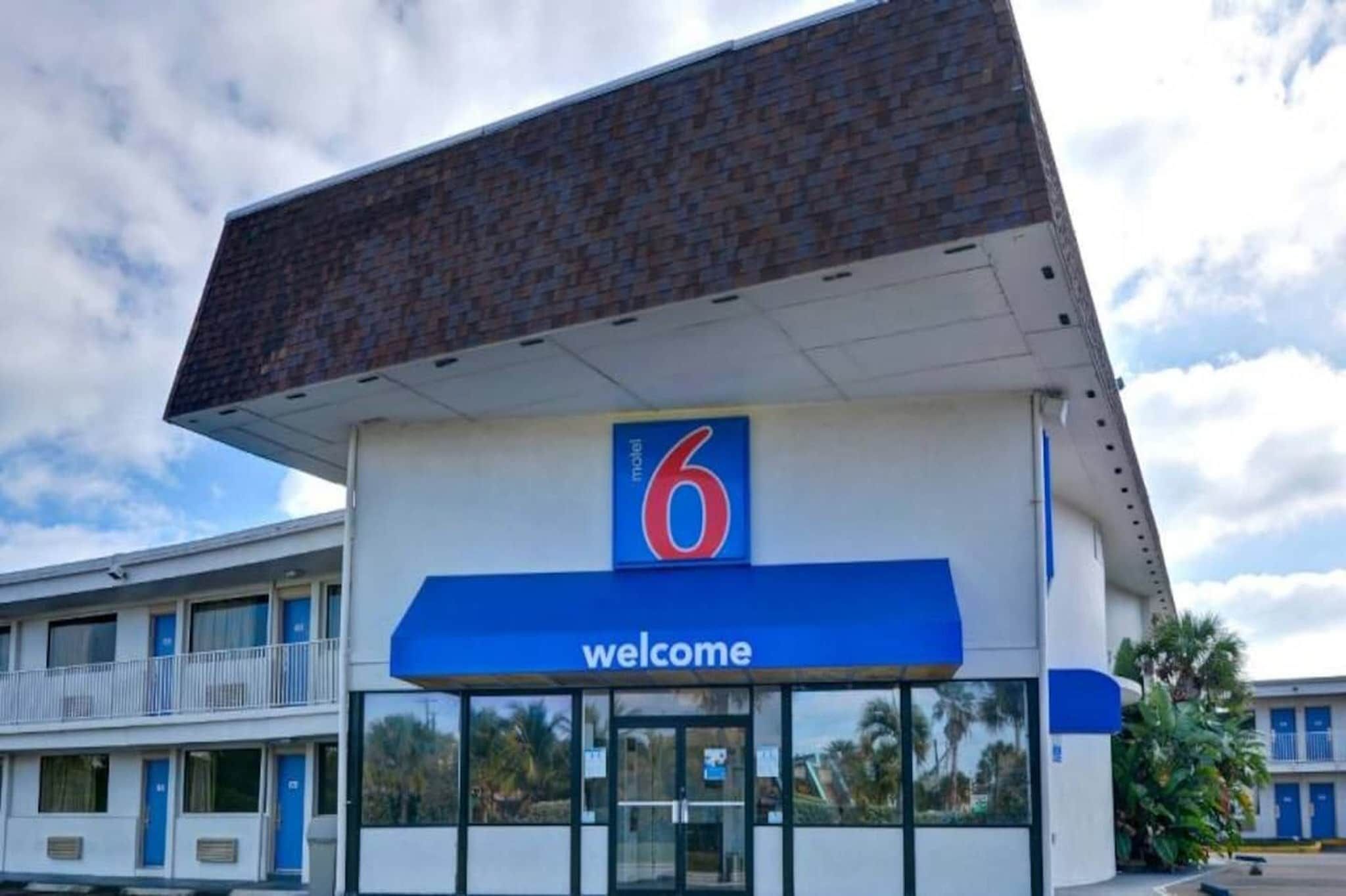Een motel met een opvallend nummer '6' bord en een 'welkom'-banner.