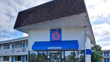Een motel met een opvallend nummer '6' bord en een 'welkom'-banner.