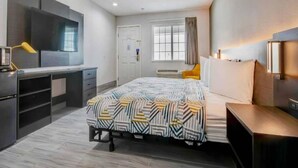 Una camera d'albergo moderna con un letto, una scrivania e una finestra.