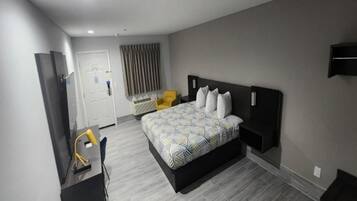 Una habitación de hotel moderna con una cama grande, un escritorio y una silla.