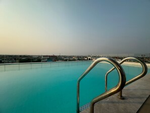 Una piscina amb una barana metàl·lica, envoltada d'edificis.