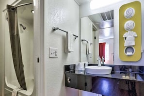 A bathroom with a shower, a sink, and a mirror. - 2 Full Beds |  Flagstaff (Flaggstaff)