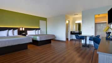 Une chambre d’hôtel avec deux lits, un bureau et une chaise.