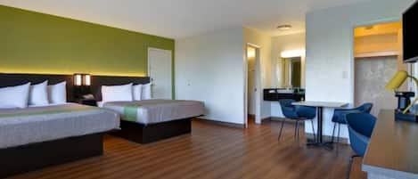 Une chambre d’hôtel avec deux lits, un bureau et une chaise.