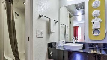 Un baño con ducha, lavabo y espejo.