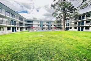 A courtyard with a swimming pool, surrounded by multi-story buildings with balconies. - 1 Full Bed|ADA/Tub/Micfridge (Flagstaff AZ)