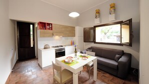 A compact living space with a kitchenette, dining area, and a sofa. - Vrbo Property (Fornazzo)