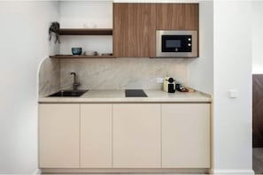 Une cuisine moderne équipée d’un four à micro-ondes encastré, d’un évier et d’un plan de travail.