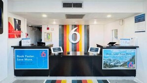 Un área de recepción con un gran número 6 en la pared, dos mostradores de recepción y carteles informativos.