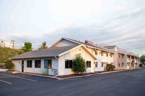 A motel with a single-story structure, a parking lot, and a small front yard. - 1 Queen Bed | Smoking (Omaha NE)