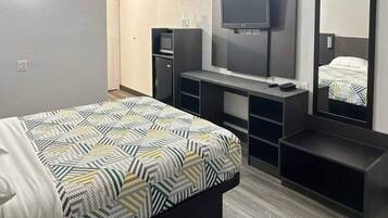 A hotel room with a bed, a TV, a desk, and a wardrobe.