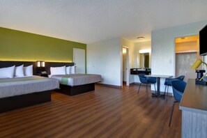 Una habitación de hotel con dos camas, un escritorio y una silla.