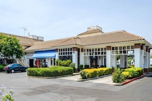 A commercial building with a tiled roof, a blue awning, and a parking lot. - 2 Queen Beds | Non-Smoking (OAKDALE)