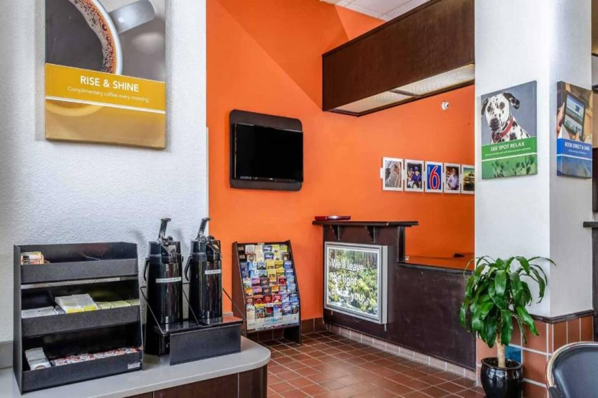 A reception area with a coffee machine, a bulletin board, and a television.