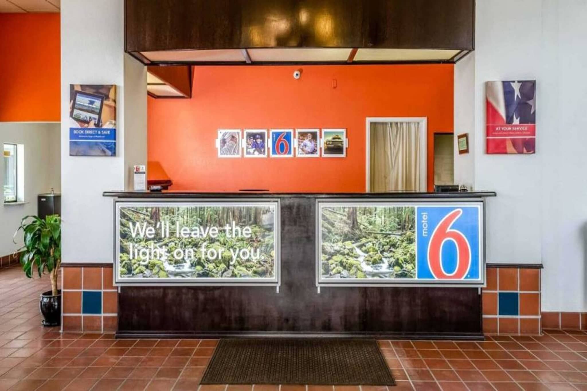 Un mostrador de recepción de hotel con un cartel grande que dice 'Dejaremos la luz encendida para ti'.