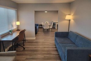 A compact living space with a sofa, a desk, and a dining area. - 2 Full Beds|Premium,Mini Fridge (Las Vegas)